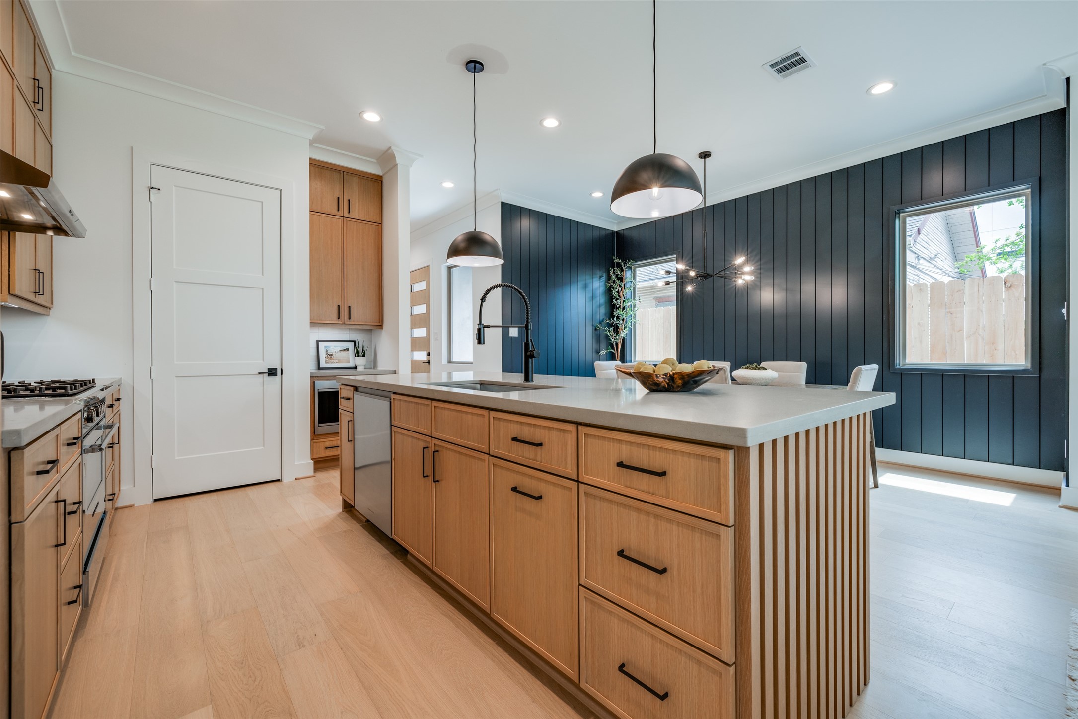 2327 Richton Street Houston, TX 77098 - Photo 13 of 47 a large kitchen with granite countertop a large kitchen island white cabinets and stainless steel appliances
