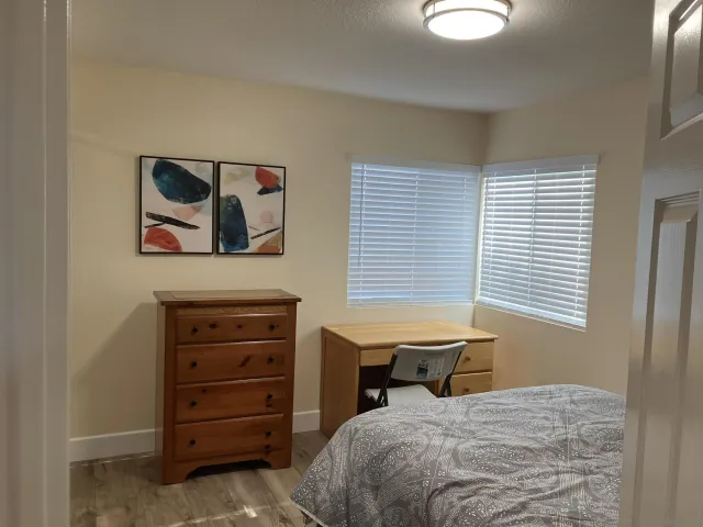 a bedroom with a bed and a painting on the wall