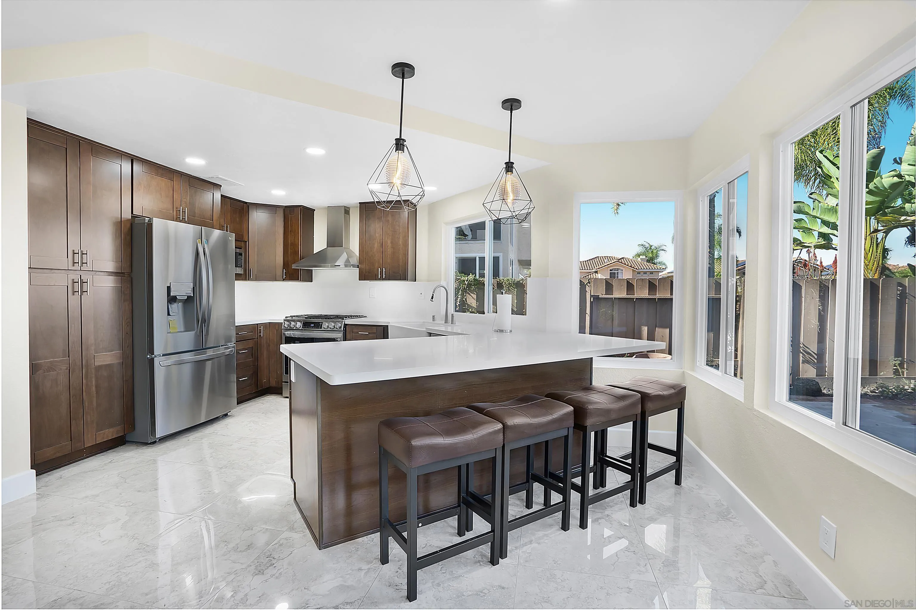8418 Hovenweep Court San Diego, CA 92129 - Photo 2 of 29 a kitchen with kitchen island a refrigerator a stove a dining table and chairs