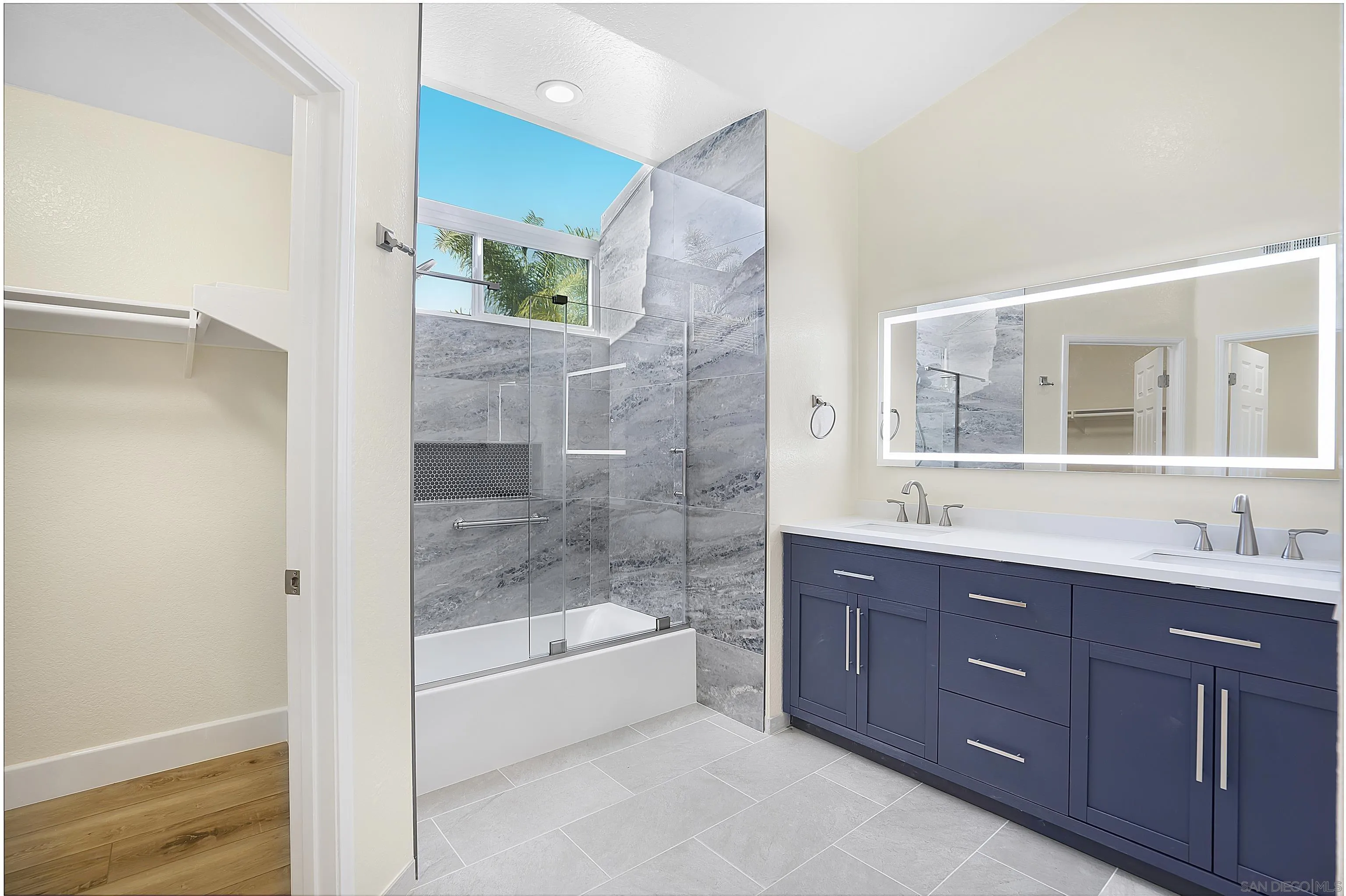 8418 Hovenweep Court San Diego, CA 92129 - Photo 22 of 29 a bathroom with a tub a double vanity sink and mirror