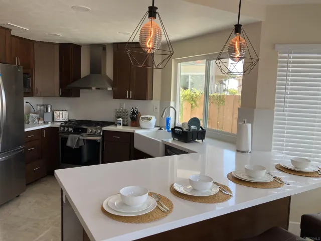 a kitchen with stainless steel appliances wooden floor dining table and chairs