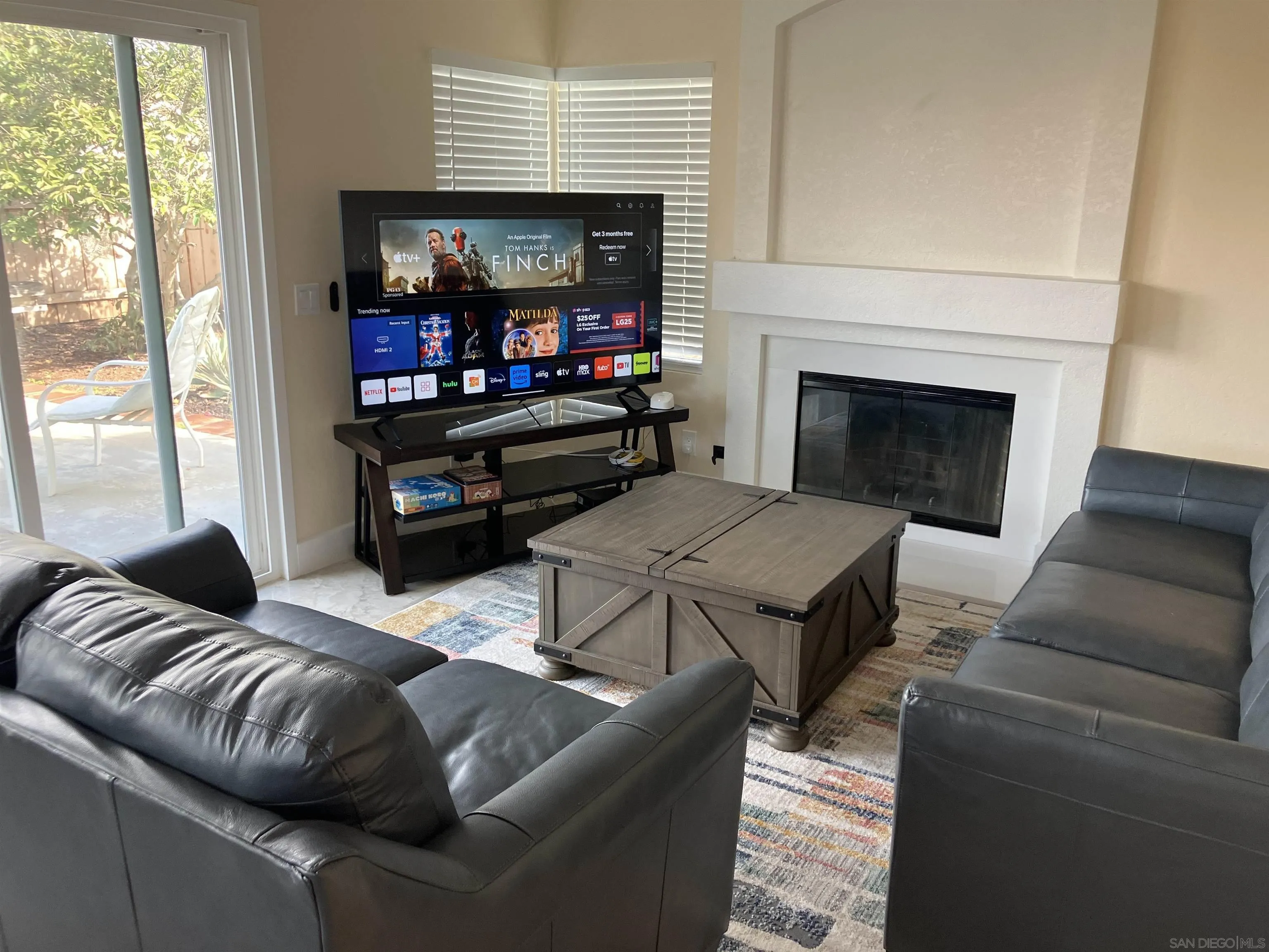 8418 Hovenweep Court San Diego, CA 92129 - Photo 8 of 29 a living room with furniture a flat screen tv and a fireplace
