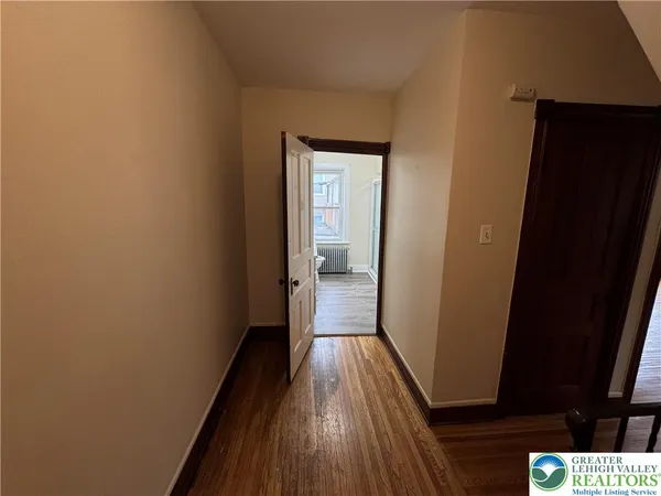 a view of a hallway with wooden floor and staircase