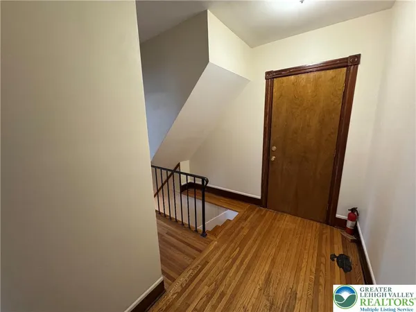a view of a hallway with wooden floor and staircase