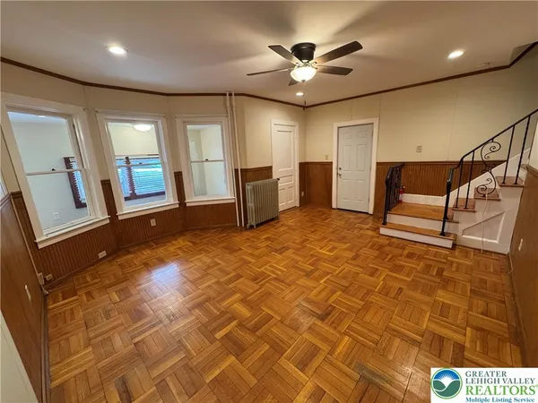 a view of empty room with wooden floor