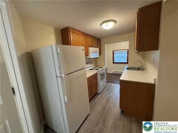 a kitchen with a refrigerator sink and wooden floor