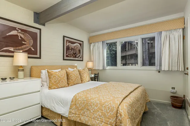 a bedroom with a bed and a potted plant