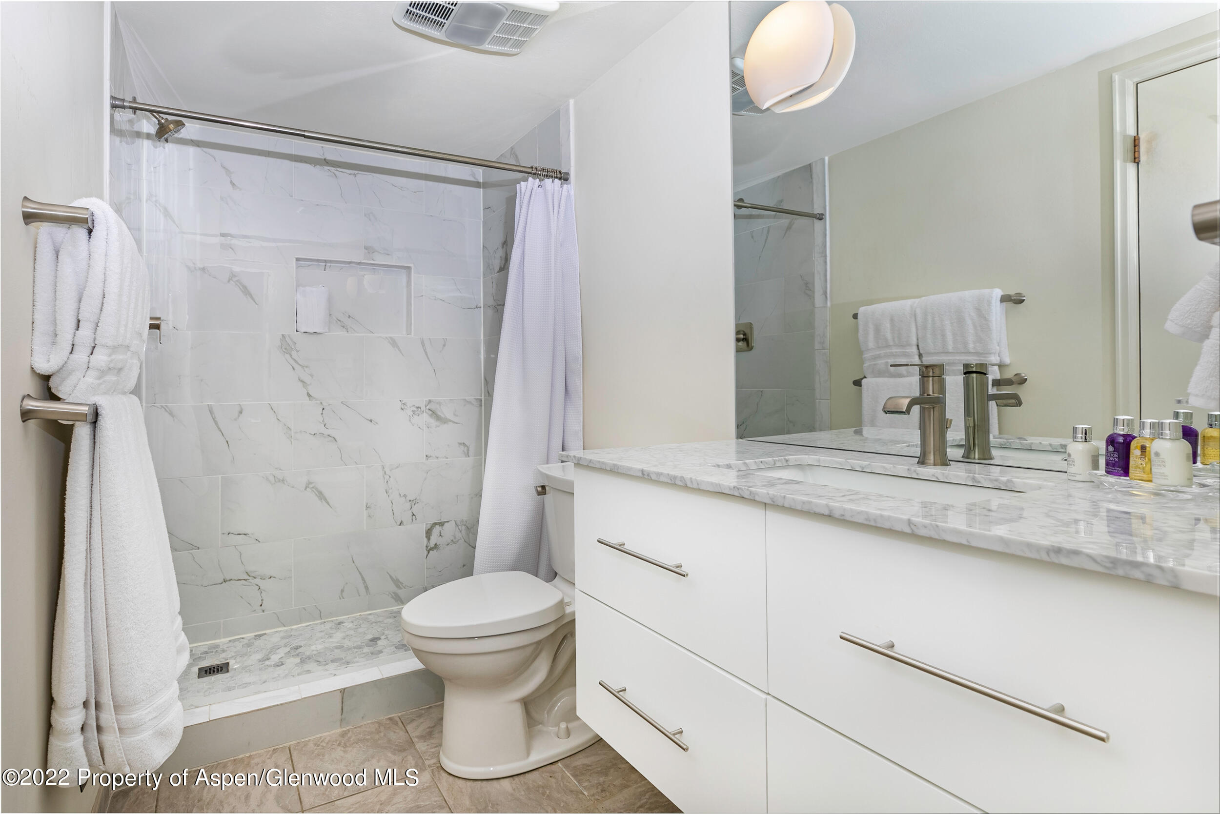 625 South W End Street, Unit 15 Aspen, CO 81611 - Photo 7 of 14 a bathroom with a granite countertop sink toilet a mirror and shower