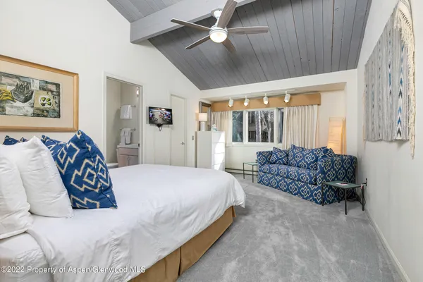 a spacious bedroom with a bed and ceiling fan