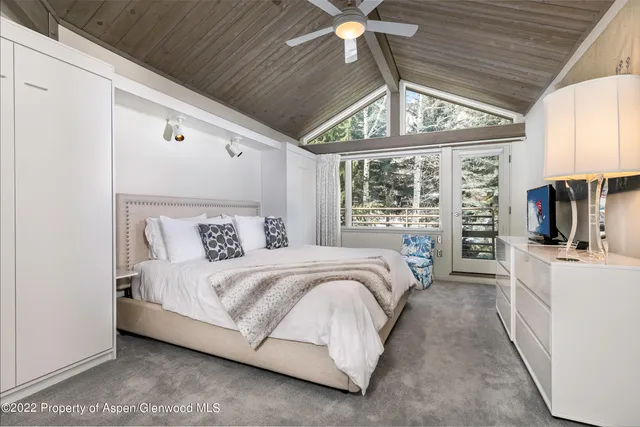 a large bed sitting in a bedroom next to a window