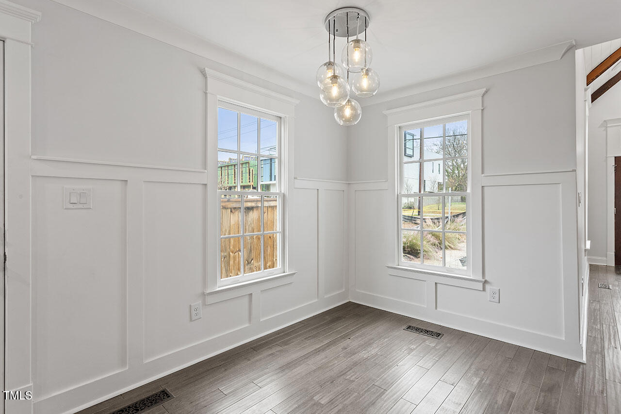 520 South Bloodworth Street Raleigh, NC 27601 - Photo 3 of 37 an empty room with wooden floor chandelier and windows