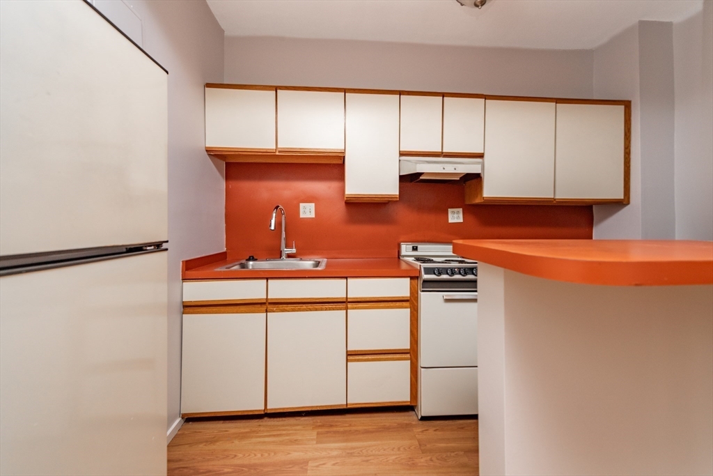 31 Orkney Road, Unit 5 Boston, MA 02135 - Photo 3 of 8 a kitchen with stainless steel appliances granite countertop a sink stove and cabinets