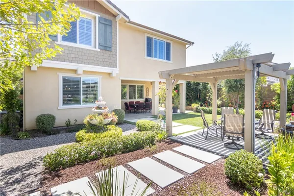 a view of a house with backyard sitting area and garden