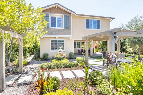 a view of a house with backyard sitting area and garden