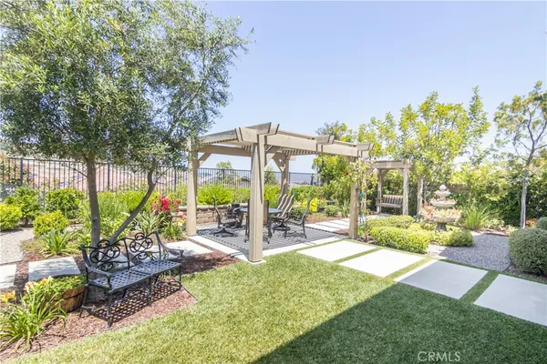 a view of a patio with table and chairs potted plants and large tree