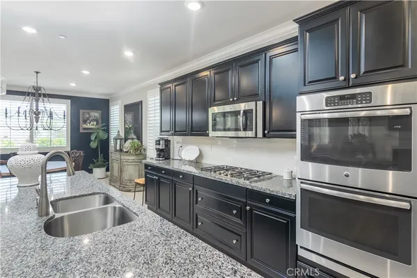 a kitchen with stainless steel appliances granite countertop a sink and stove top oven