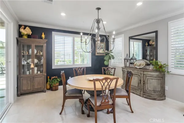 a dining room with furniture a chandelier and window