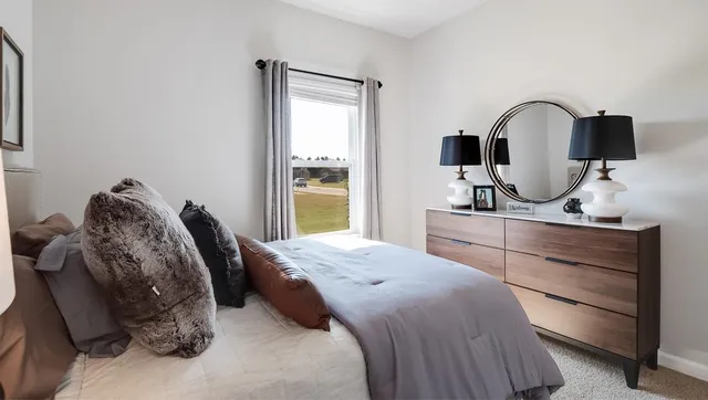 a bedroom with a bed and a large window