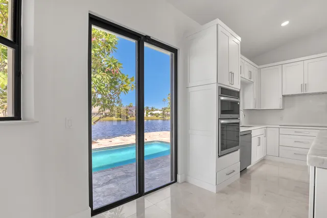 a view of an empty room and a kitchen
