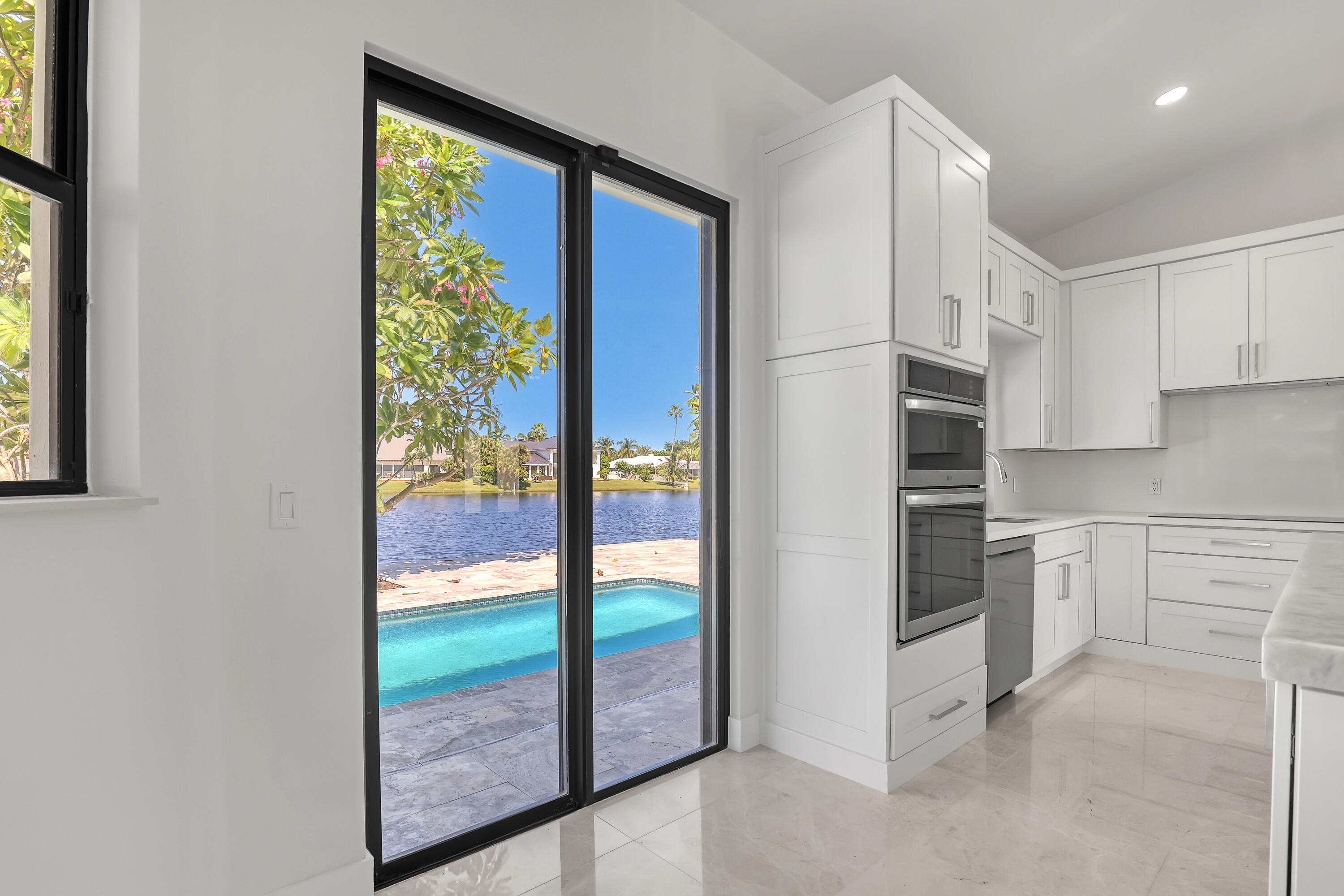 161 Apollo Circle Jupiter, FL 33477 - Photo 18 of 60 a kitchen with white cabinets and white appliances
