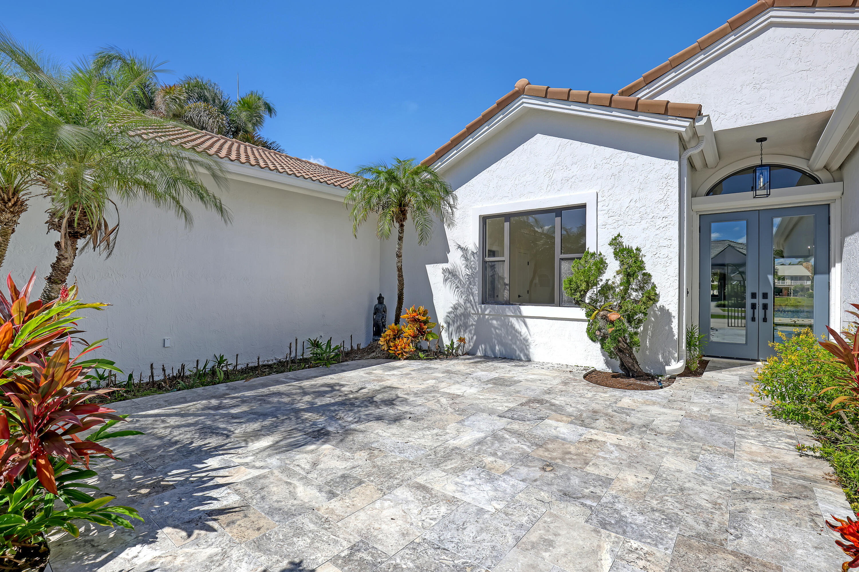 161 Apollo Circle Jupiter, FL 33477 - Photo 33 of 60 a view of a house with potted plants next to a road