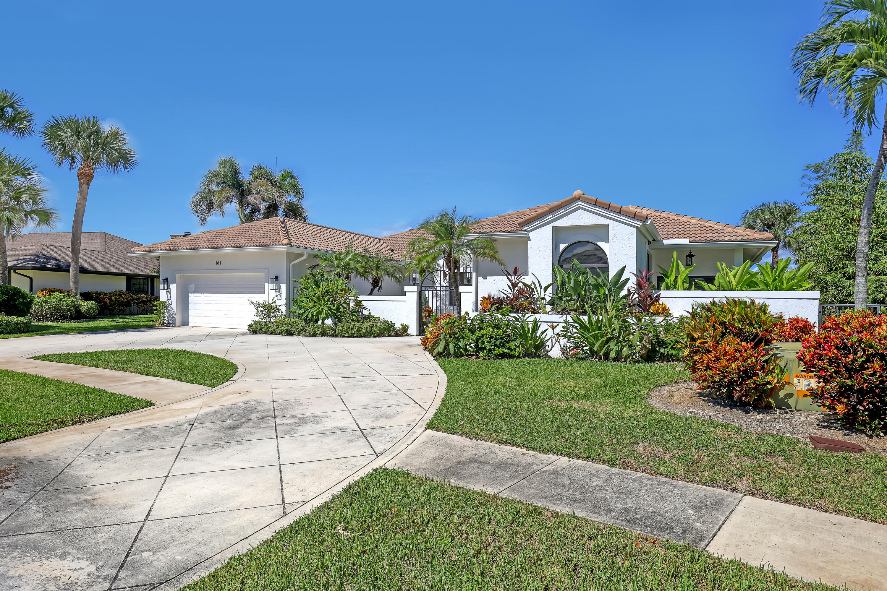 161 Apollo Circle Jupiter, FL 33477 - Photo 36 of 60 a front view of a house with garden