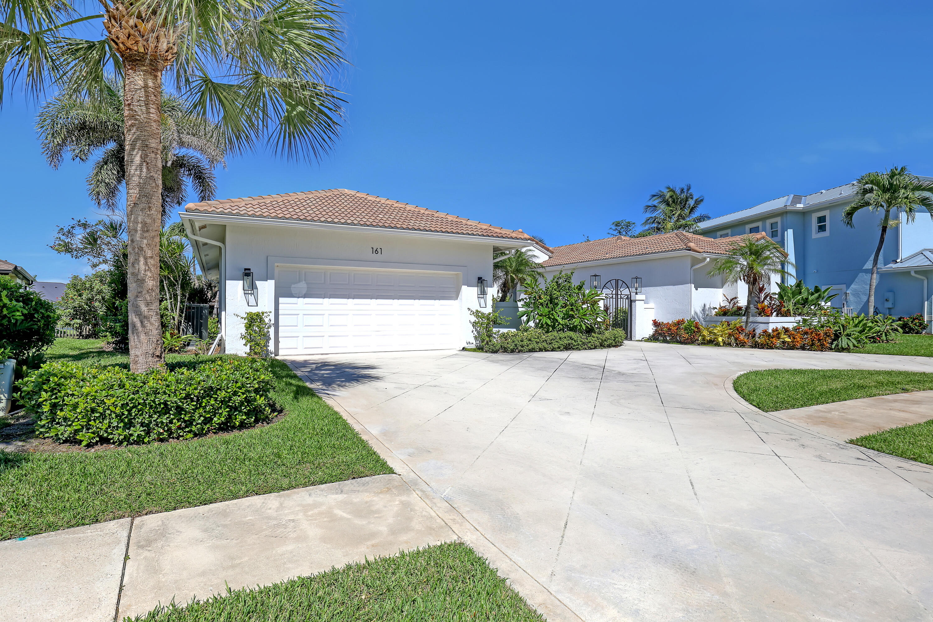161 Apollo Circle Jupiter, FL 33477 - Photo 37 of 60 a front view of a house with a yard and garage