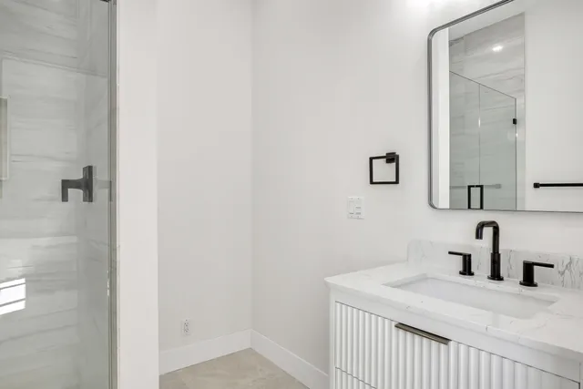 an empty room with chandelier fan and windows