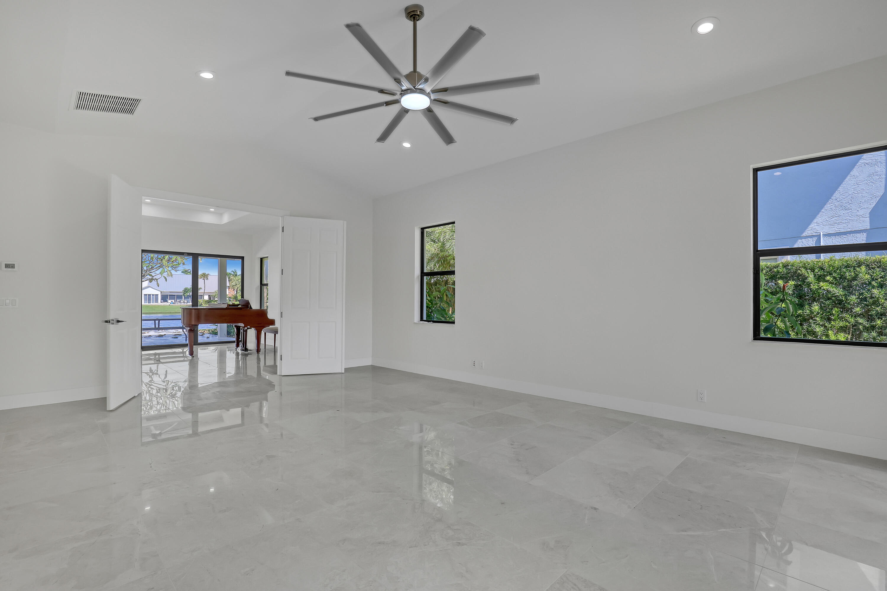 161 Apollo Circle Jupiter, FL 33477 - Photo 48 of 60 an empty room with chandelier fan and windows