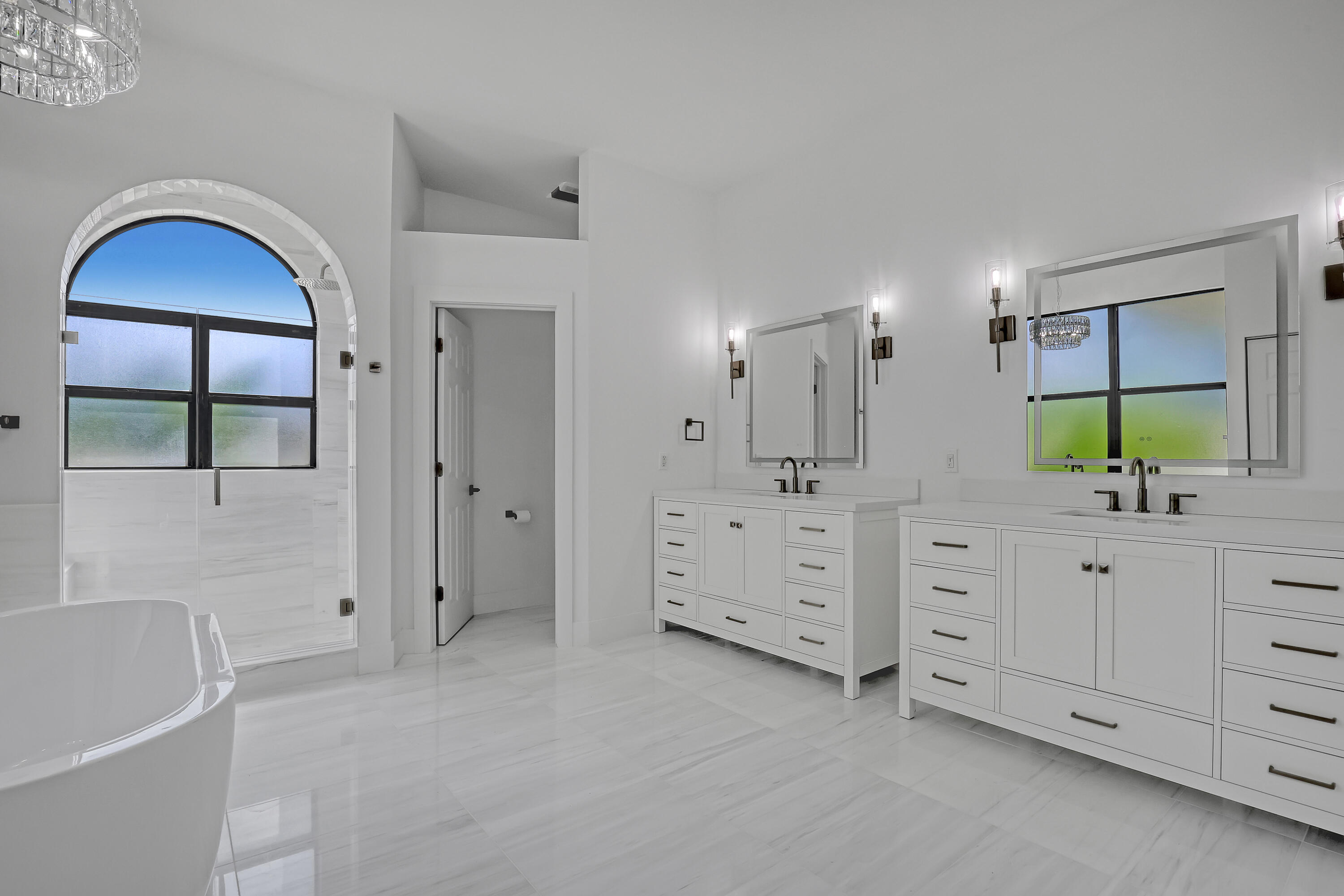 161 Apollo Circle Jupiter, FL 33477 - Photo 50 of 60 a spacious bathroom with a double vanity sink a large mirror and a bathtub