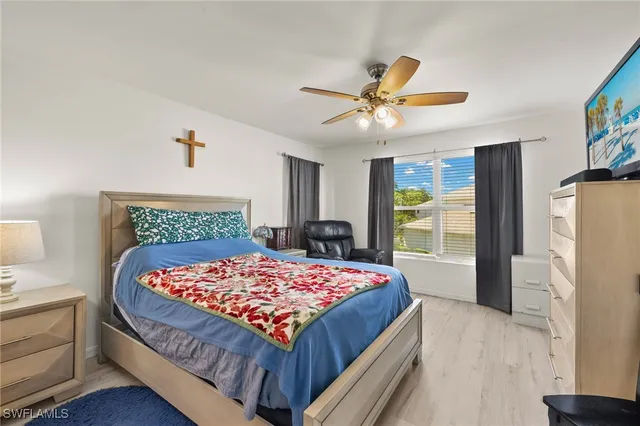 a bedroom with a bed and a refrigerator