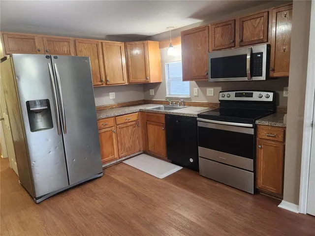a kitchen with stainless steel appliances granite countertop a refrigerator and a stove top oven