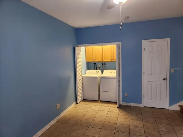a view of a refrigerator in kitchen and an empty room