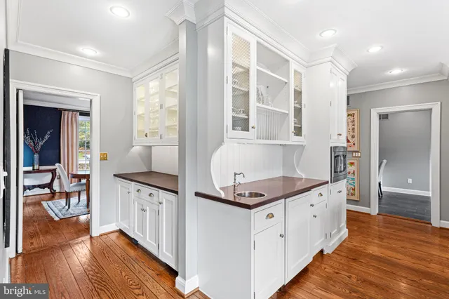 a kitchen that has a lot of cabinets in it and wooden floors