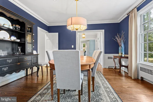 a view of a dining room with furniture a chandelier and wooden floor