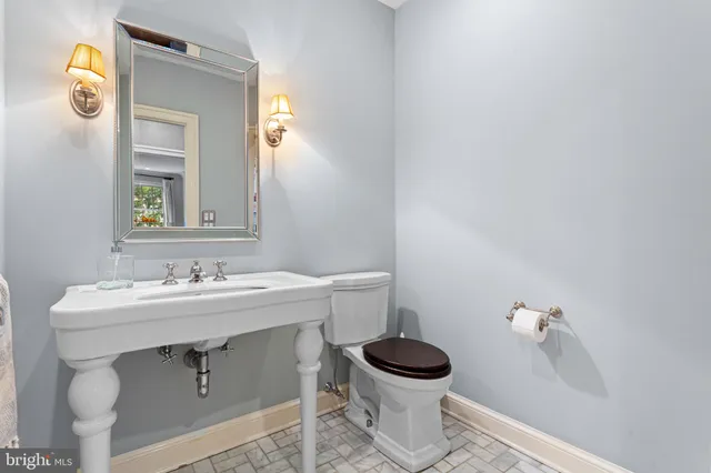 a bathroom with a toilet a sink and mirror