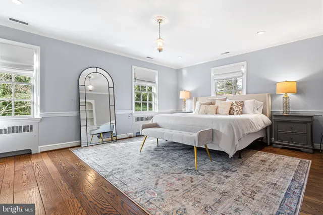 a spacious bedroom with a bed and wooden floor