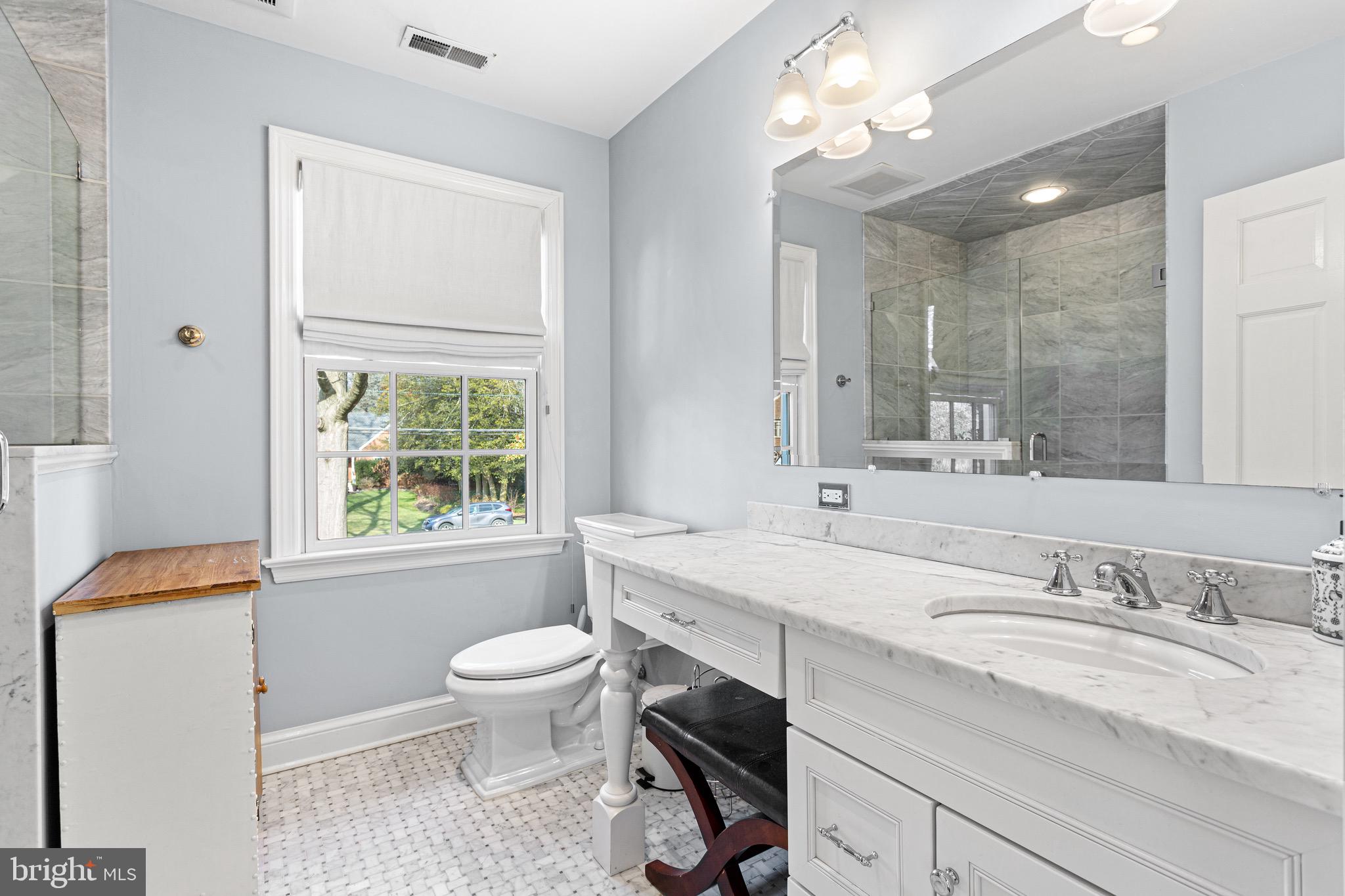 370 Station Avenue Haddonfield, NJ 08033 - Photo 32 of 48 a bathroom with a granite countertop sink toilet a large mirror and a window