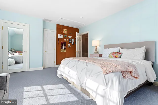 a spacious bedroom with a bed and a large mirror