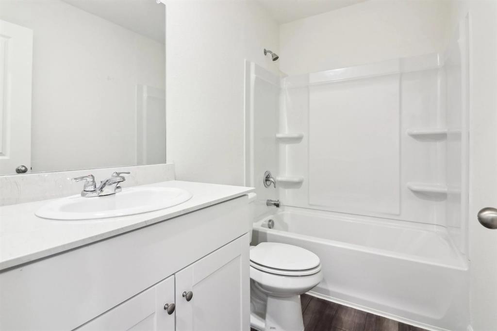 14126 Donahue Street Pilot Point, TX 76258 - Photo 20 of 21 a bathroom with a granite countertop sink toilet a mirror and bathtub