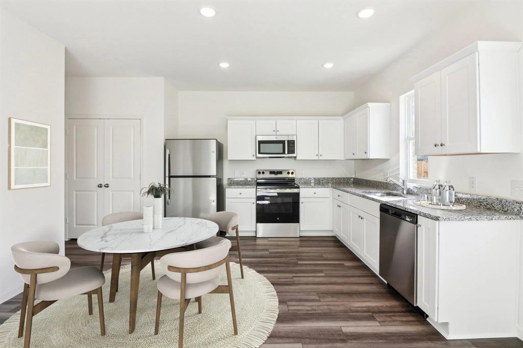 14126 Donahue Street Pilot Point, TX 76258 - Photo 6 of 21 a kitchen with granite countertop a table chairs stove and refrigerator