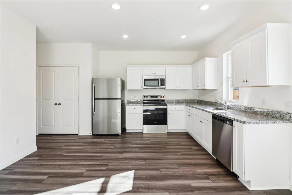 14126 Donahue Street Pilot Point, TX 76258 - Photo 10 of 21 a kitchen with granite countertop a refrigerator and a stove top oven