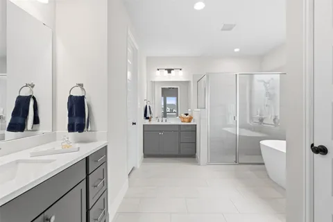 a bathroom with a double vanity sink toilet mirror and bathtub