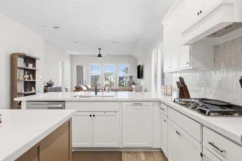 a kitchen with white cabinets and appliances