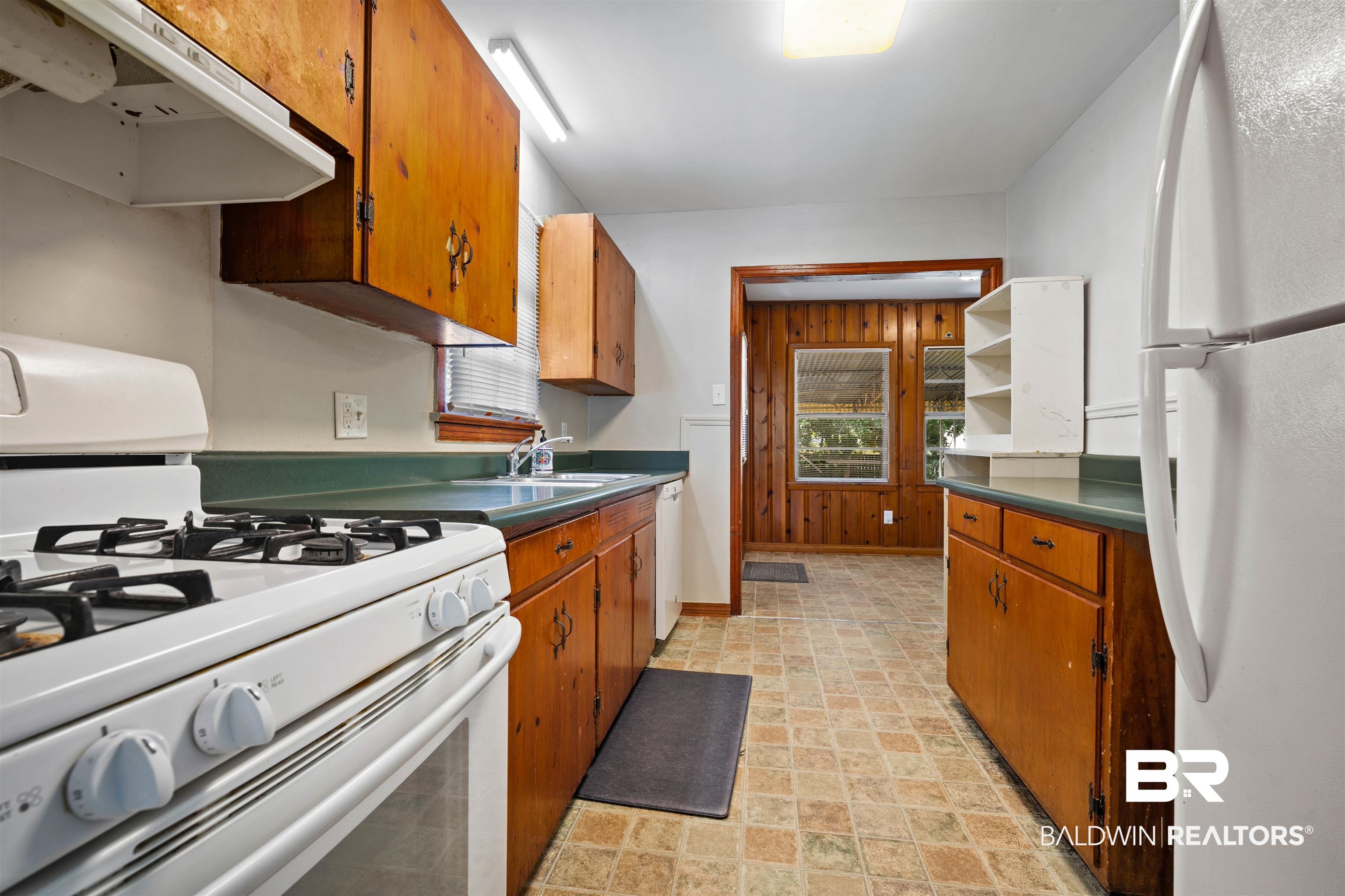 9 Elizabeth Avenue Mobile, AL 36611 - Photo 10 of 19 Kitchen with white appliances, exhaust hood, brown cabinetry, and dark countertops