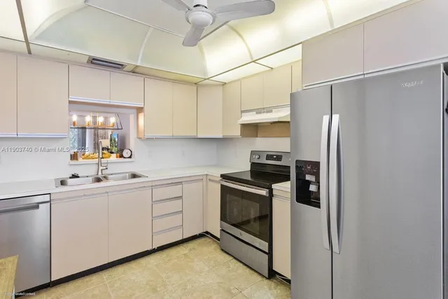 a kitchen with stainless steel appliances a sink cabinets and a refrigerator