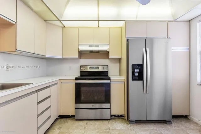 a kitchen with cabinets and stainless steel appliances