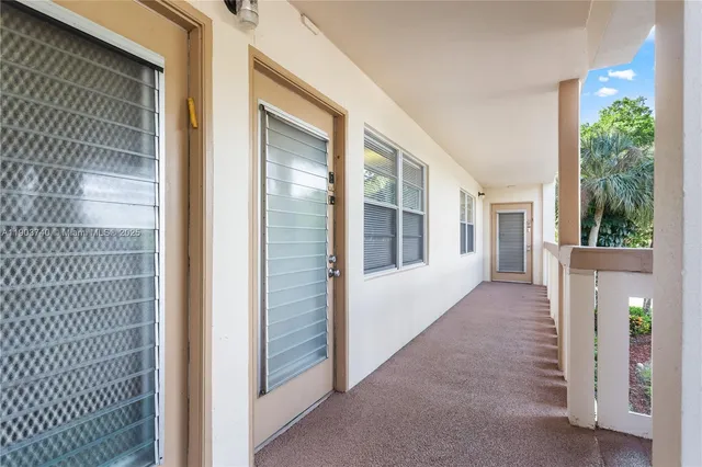 a view of a porch with a door and wooden floor