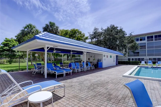 a view of a patio with table and chairs under an umbrella