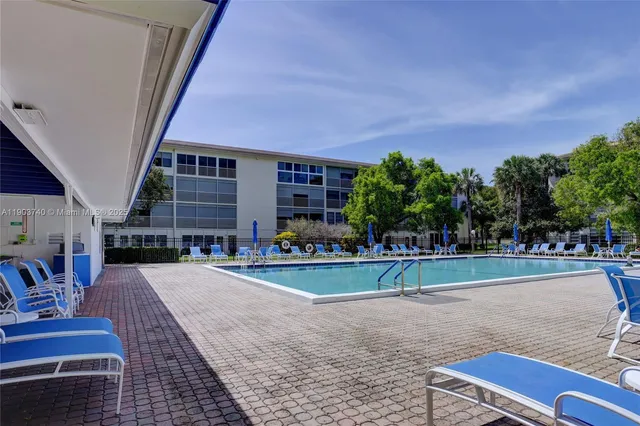 a view of a house with backyard and trees